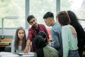 A group of students having a discussion with a colleague during a meeting.